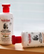 A picture of two bottles of the Thayers Milky Toner on a wooden beam