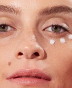 person applying eye cream under eye