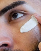 Model applying skin cream to cheek