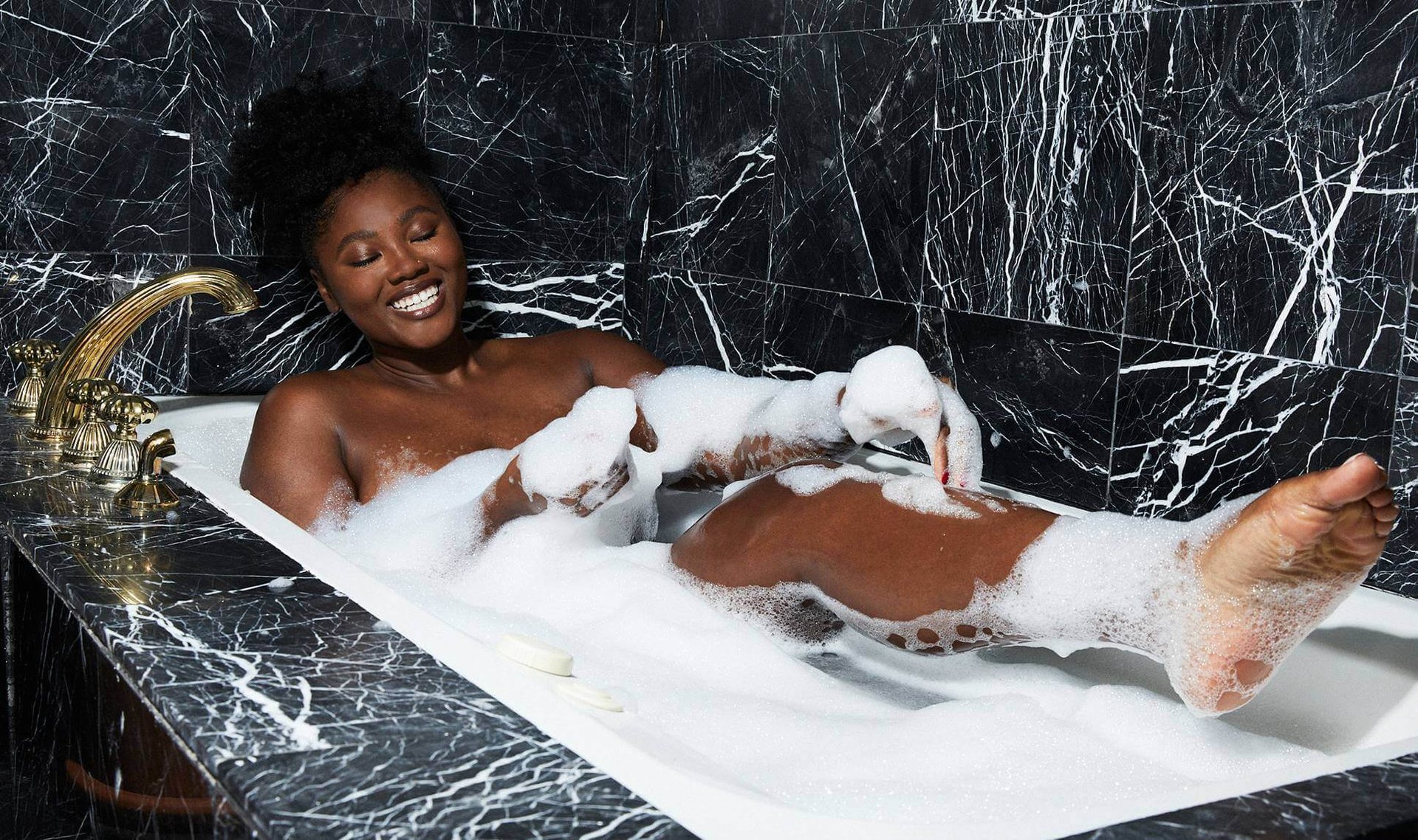 person in bathtub filled with water and bubbles