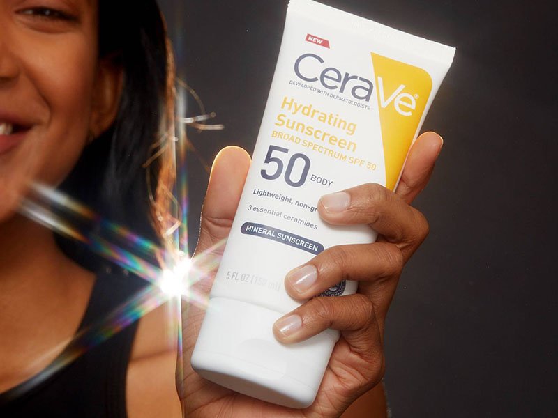 person holding cerave sunscreen