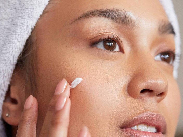 Person applying spot treatment to their cheek
