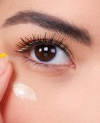 Person putting cream underneath eye