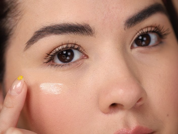 Person applying eye cream