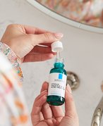 person holding la roche posay bottle