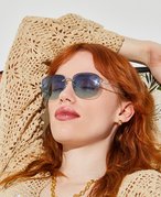 Picture of a red-haired model reclining and wearing sunglasses