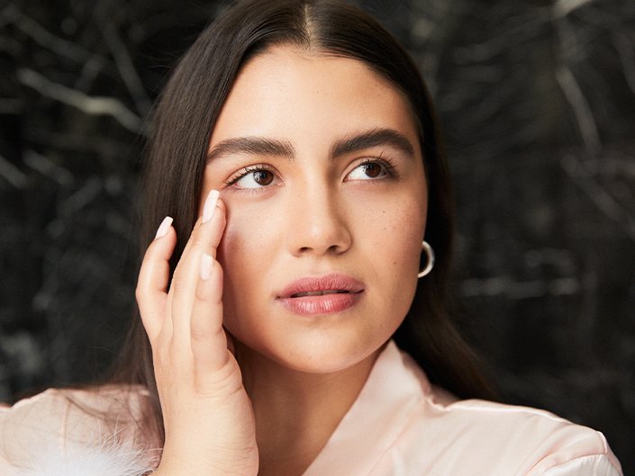 person touching their under-eye area