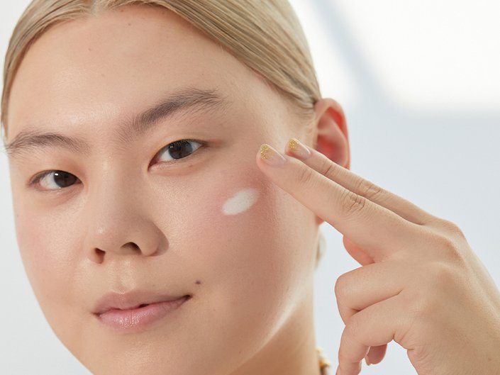 person applying skincare to their face