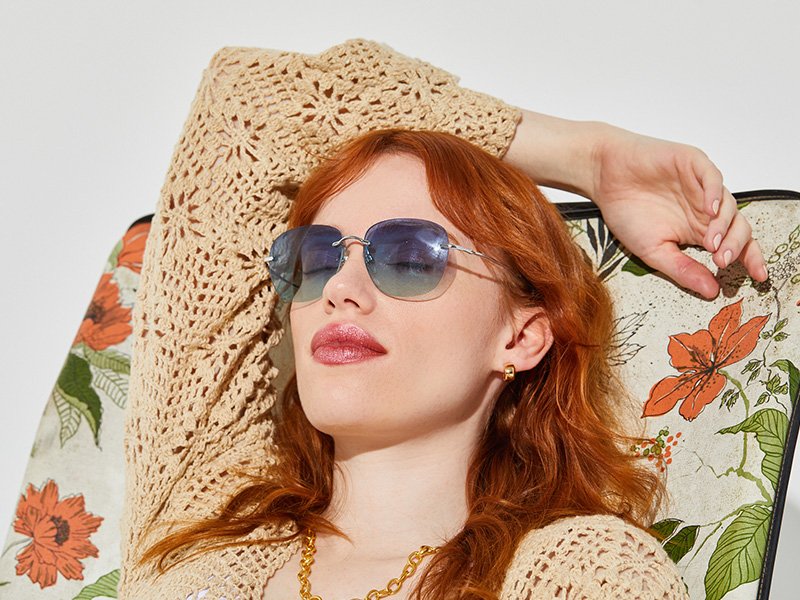 A person lounging in a floral beach chair with sunglasses on
