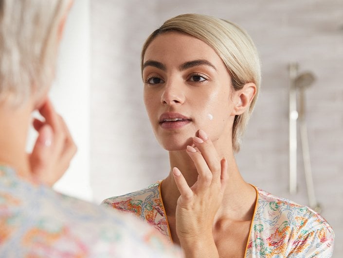 Person applying spot treatment to their skin