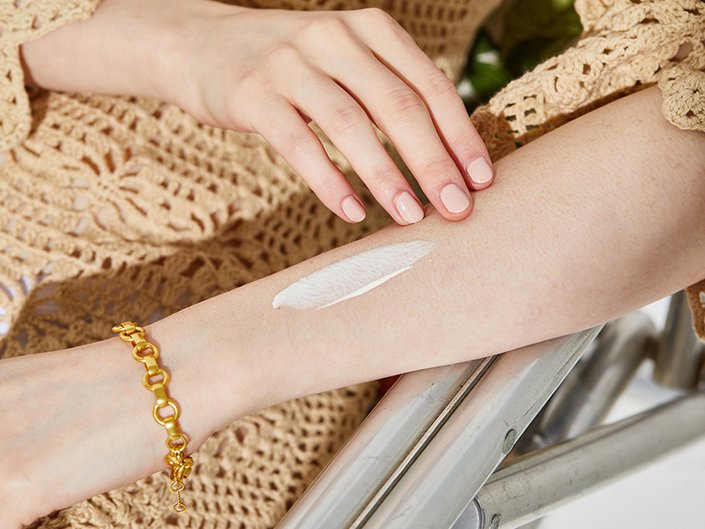 Person's forearm with a swatch of white product on it