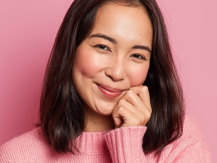 person touching face with rosy cheeks