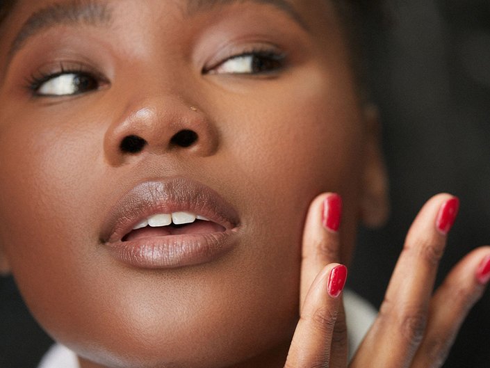 Image of a model looking to her left and touching the side of her face