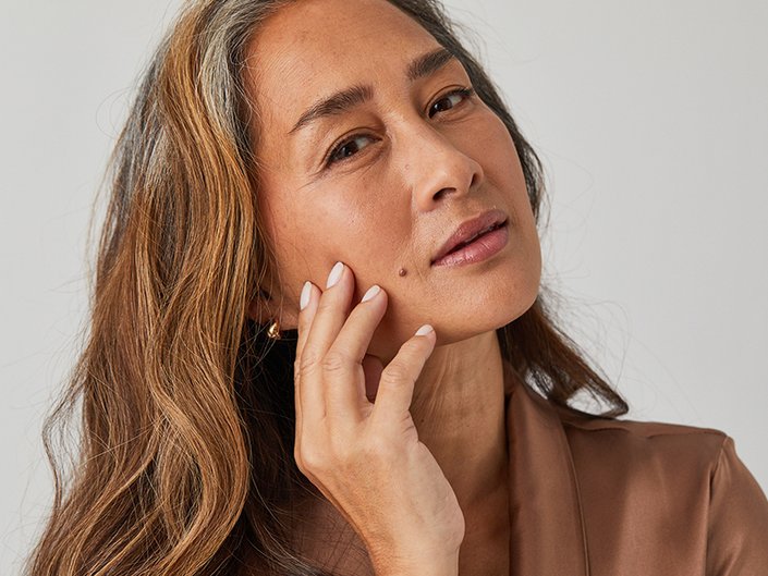 Image of a mature woman touching the side of her face