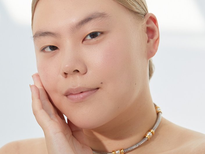 Photo of model looking at camera and touching her cheek