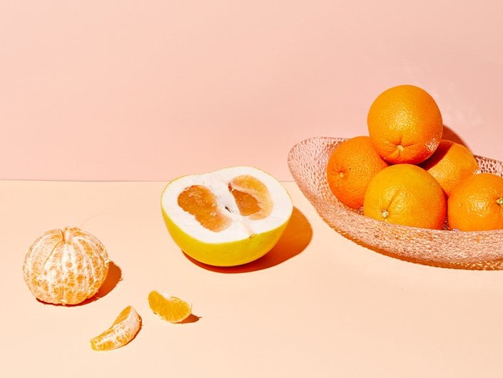 A picture of a bowl of oranges, with one sliced open