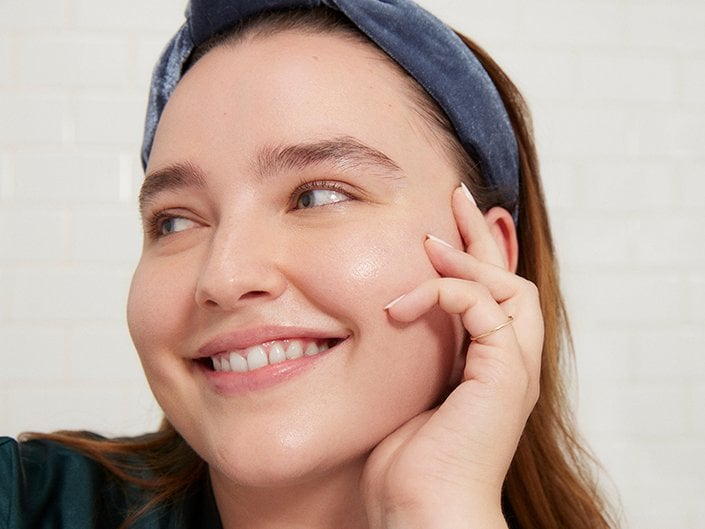 Person smiling and holding her face in her hand