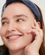 Person smiling and holding her face in her hand