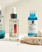 Vichy Minéral 89 Hydrating Hyaluronic Acid Serum, La Roche-Posay Hyalu B5 Hyaluronic Acid Serum and L’Oréal Paris Revitalift Derm Intensives 1.5% Hyaluronic Acid Serum serums sitting on a bathroom countertop