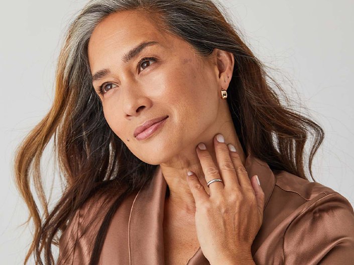 Picture of a mature model with their hand on their neck