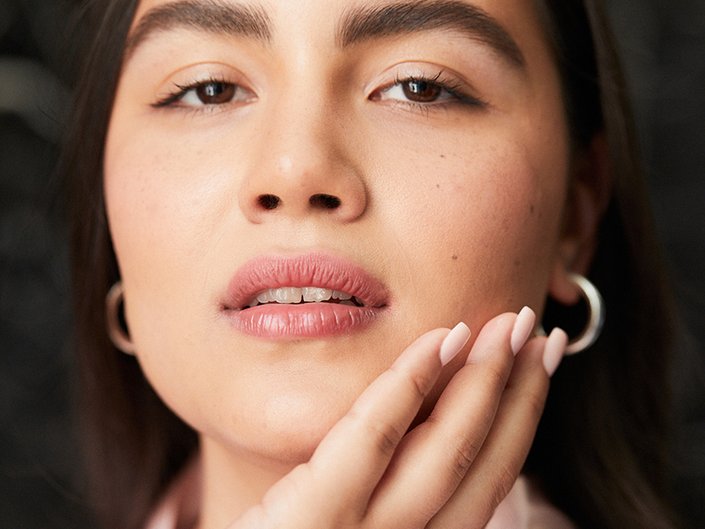 Close-up picture of a person touching the side of their face