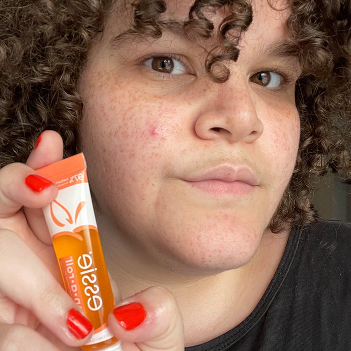 alexis posing with the Essie On a Roll Apricot Cuticle Oil