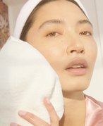 person washing face with a washcloth