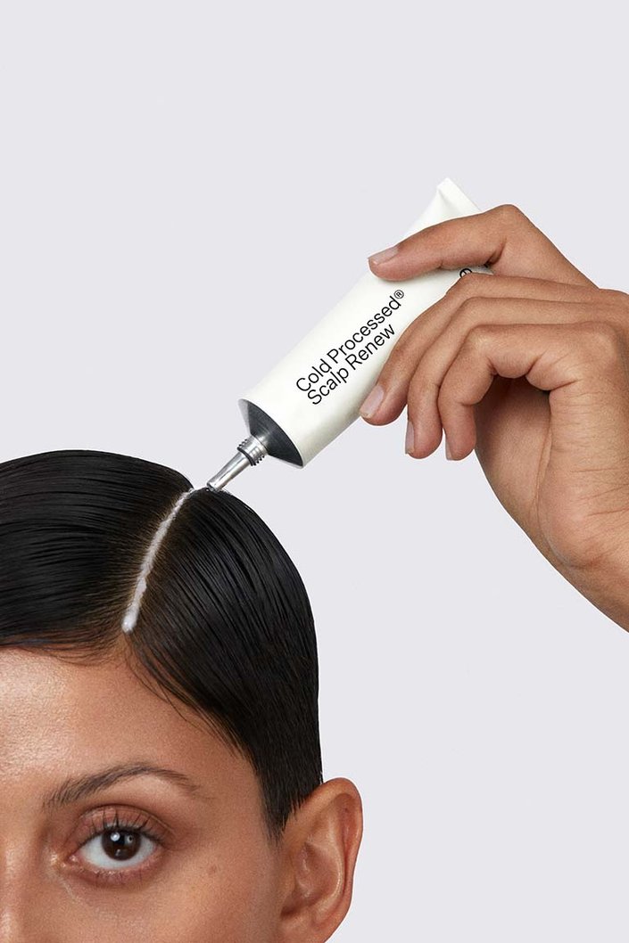 person applying act + acre scalp treatment to their scalp