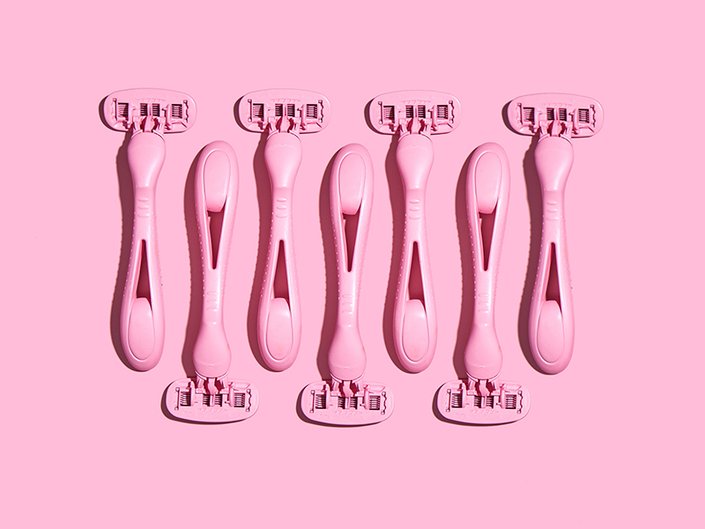 A picture of multiple pink razors on a pink background