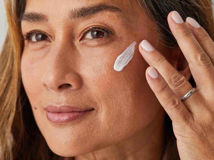 Person with white lotion swatched on their cheek