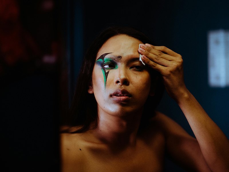 A person wiping their face with a cotton round