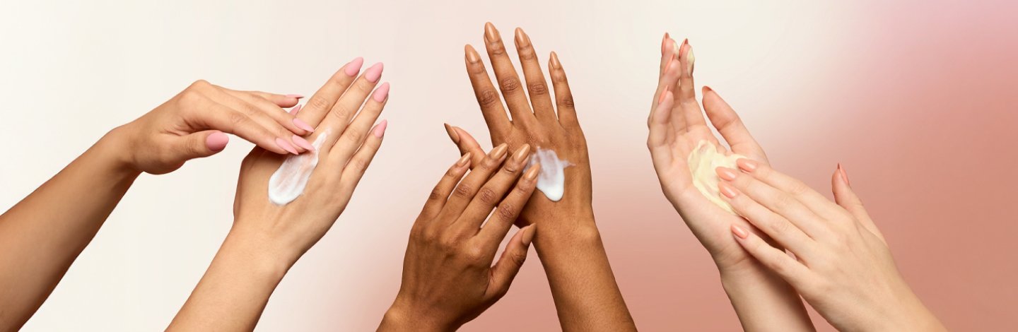 Image of multiple hands rubbing in sunscreen on a pink gradient background