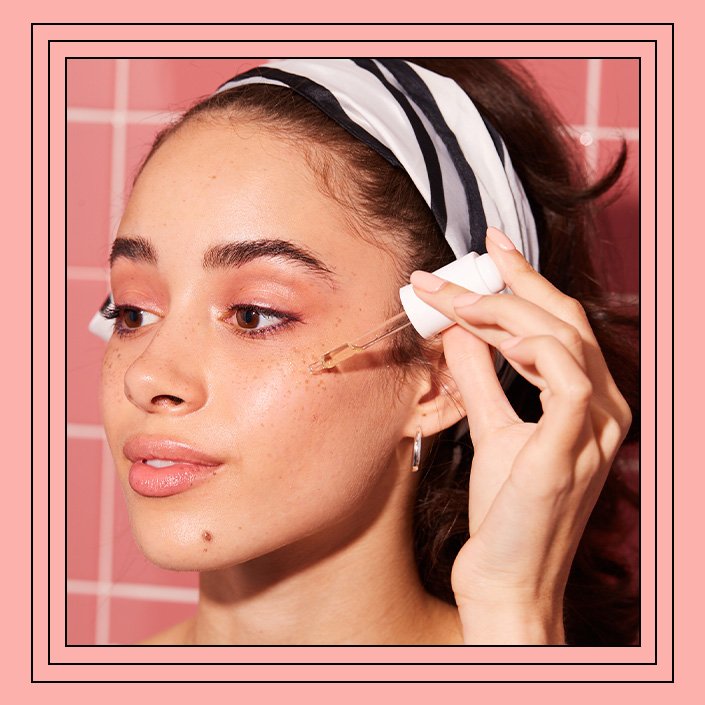 person applying serum to cheekbone