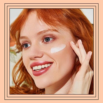 Close-up of model applying skincare product to cheek