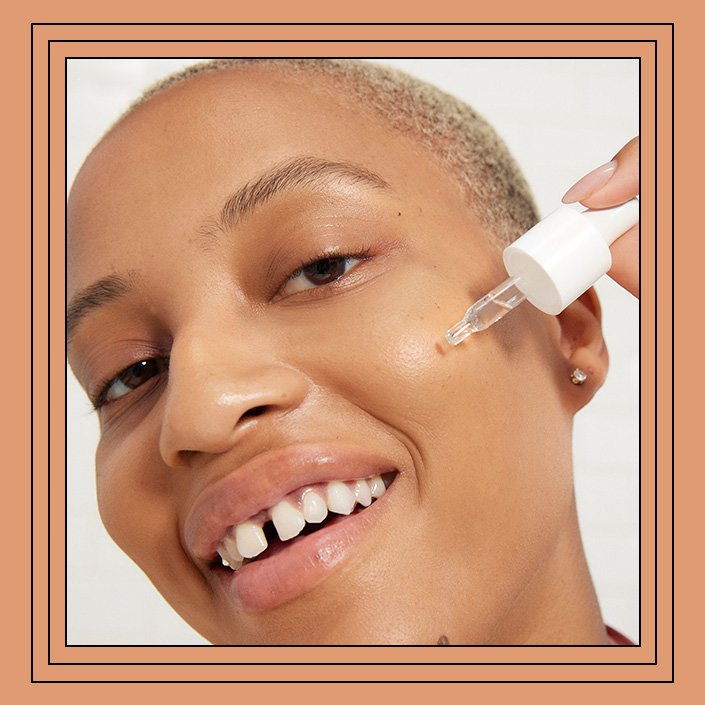 Model applying serum to cheek